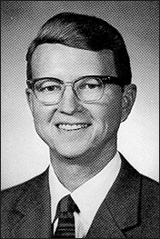 A photo of Judge Howard Dawson, Jr. He is wearing a suit and glasses and is smiling at the camera.
